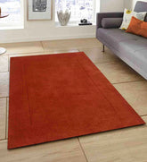 Minimalist terracotta wool rug with subtle border design